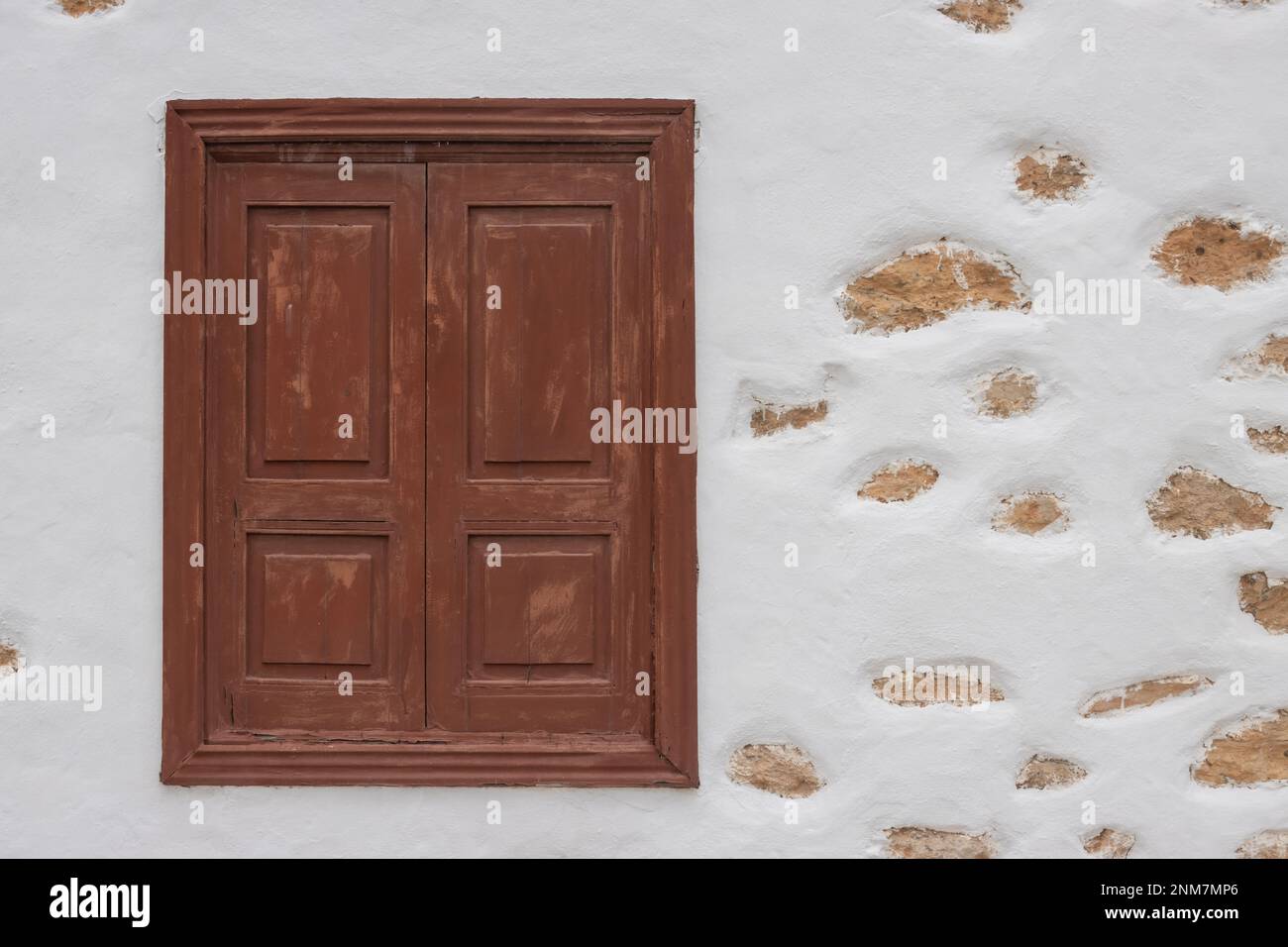 Fenêtre marron avec obturateur fermé. Façade blanche d'une maison avec des morceaux de pierres visibles et non réguliers. Tiscamanita, Fuerteventura, Îles Canaries, SP Banque D'Images