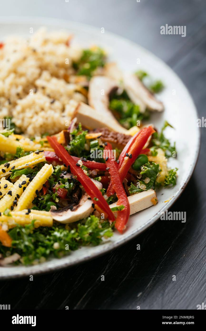 Salade de kale asiatique faite maison avec quinoa, carottes, haricots fava, poivron, maïs pour bébé, champignons et tofu fumé Banque D'Images
