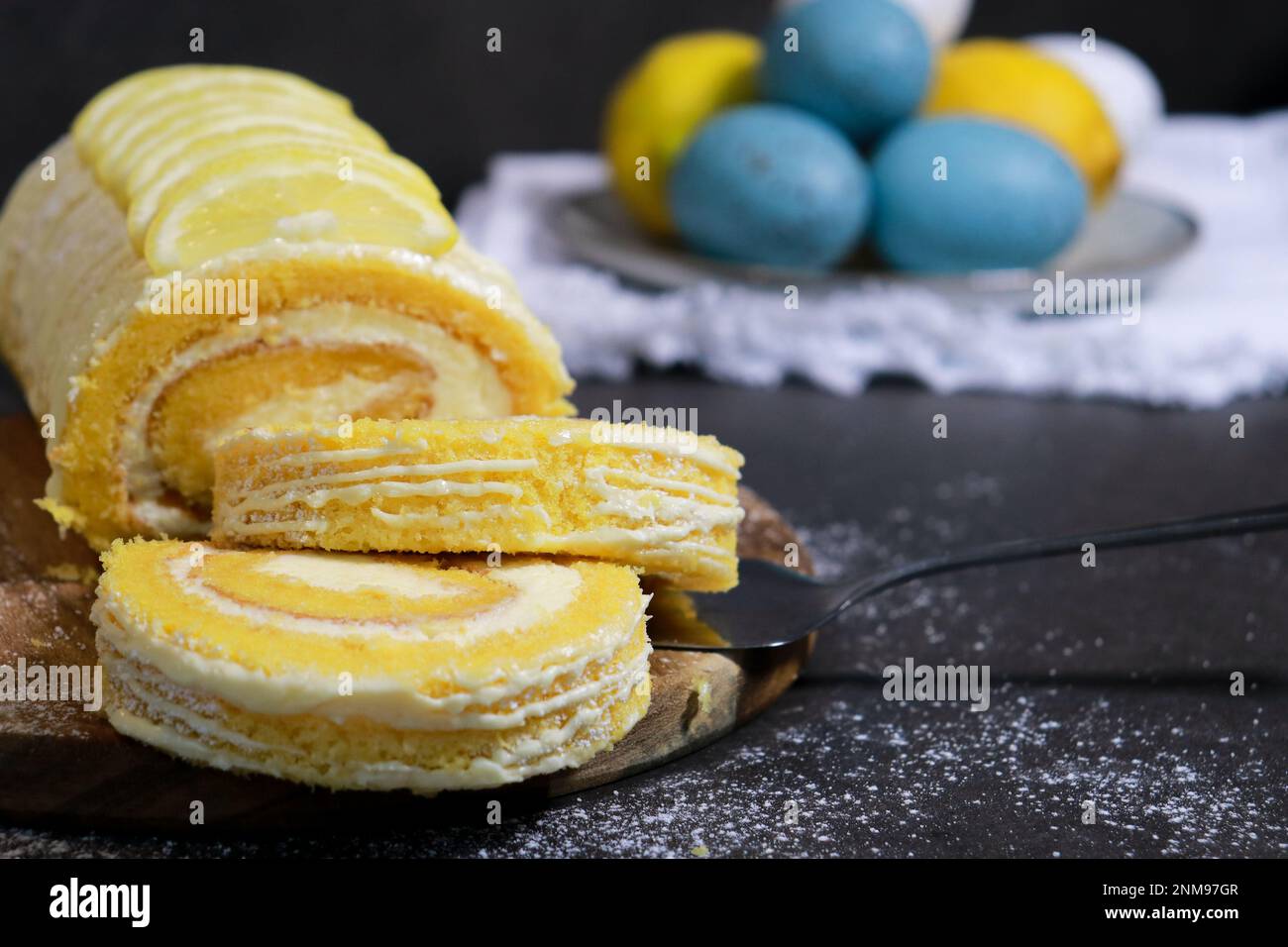 gros plan du gâteau à la vanille avec de la crème au beurre de citron à l'intérieur, œuf de pâques en arrière-plan Banque D'Images