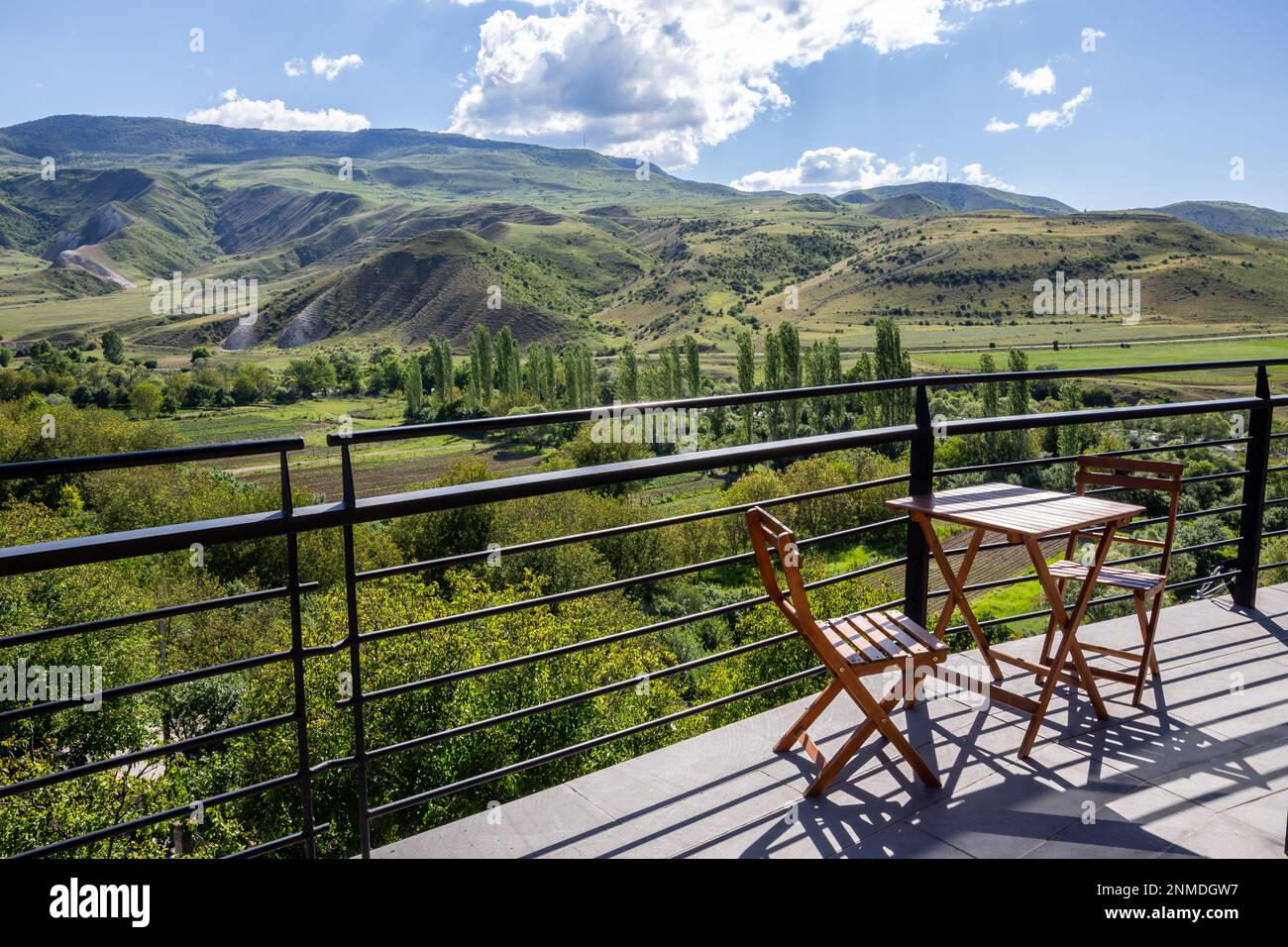 Table avec deux chaises sur une terrasse en bois dans la ville d'Asfindza, Géorgie, avec vue sur le paysage de la vallée de la rivière Mtkvari à Samtskhe - région de Javakheti. Banque D'Images