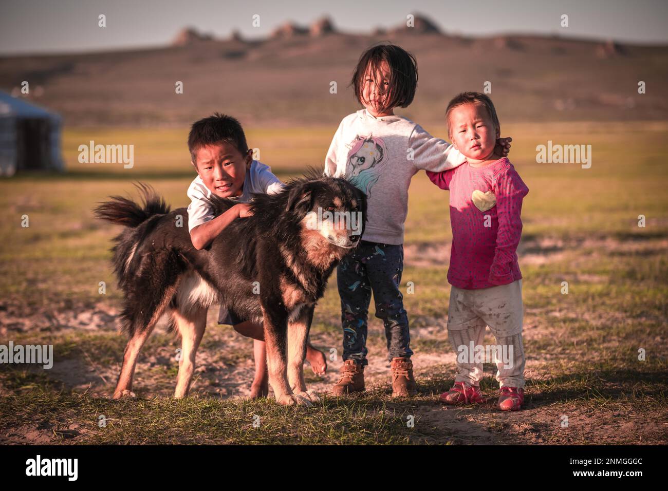 Les enfants locaux jouent avec leur chien toute la journée, en Mongolie Banque D'Images