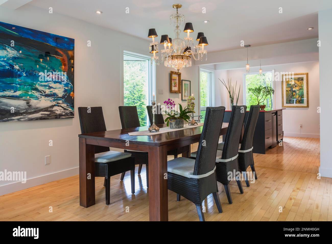 Table à manger en bois de couleur noyer avec chaises en osier noires à haut dossier dans la salle à manger à l'intérieur de la maison moderne Banque D'Images