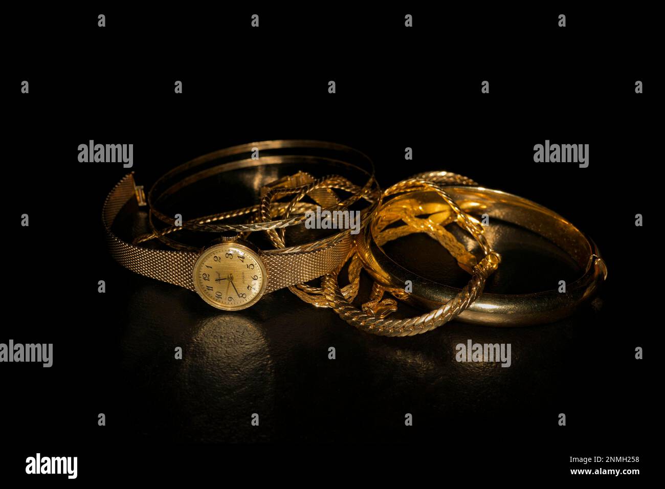 585 bijoux en or recueillis pour fondre se composant d'une montre, bracelet, collier et bracelet, photographie de studio avec fond noir Banque D'Images