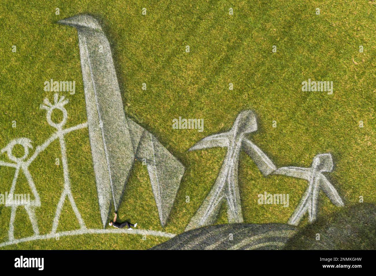 Swiss-French artist Saype (Guillaume Legros) poses in his giant ephemeral landart painting entitled "World in Progress II" representing two children drawing and building with origami their ideal world, at the Headquarters of the United Nations (U.N.) in New York City, USA, Wednesday, September 15, 2021. The artwork covering 11'000 square meters (118'000 sq ft) was produced with biodegradable paints made from natural pigments such as charcoal and chalk and constitutes the second step of a project started at the U.N. European headquarters in Geneva in 2020. The project is supported and gifted by Banque D'Images