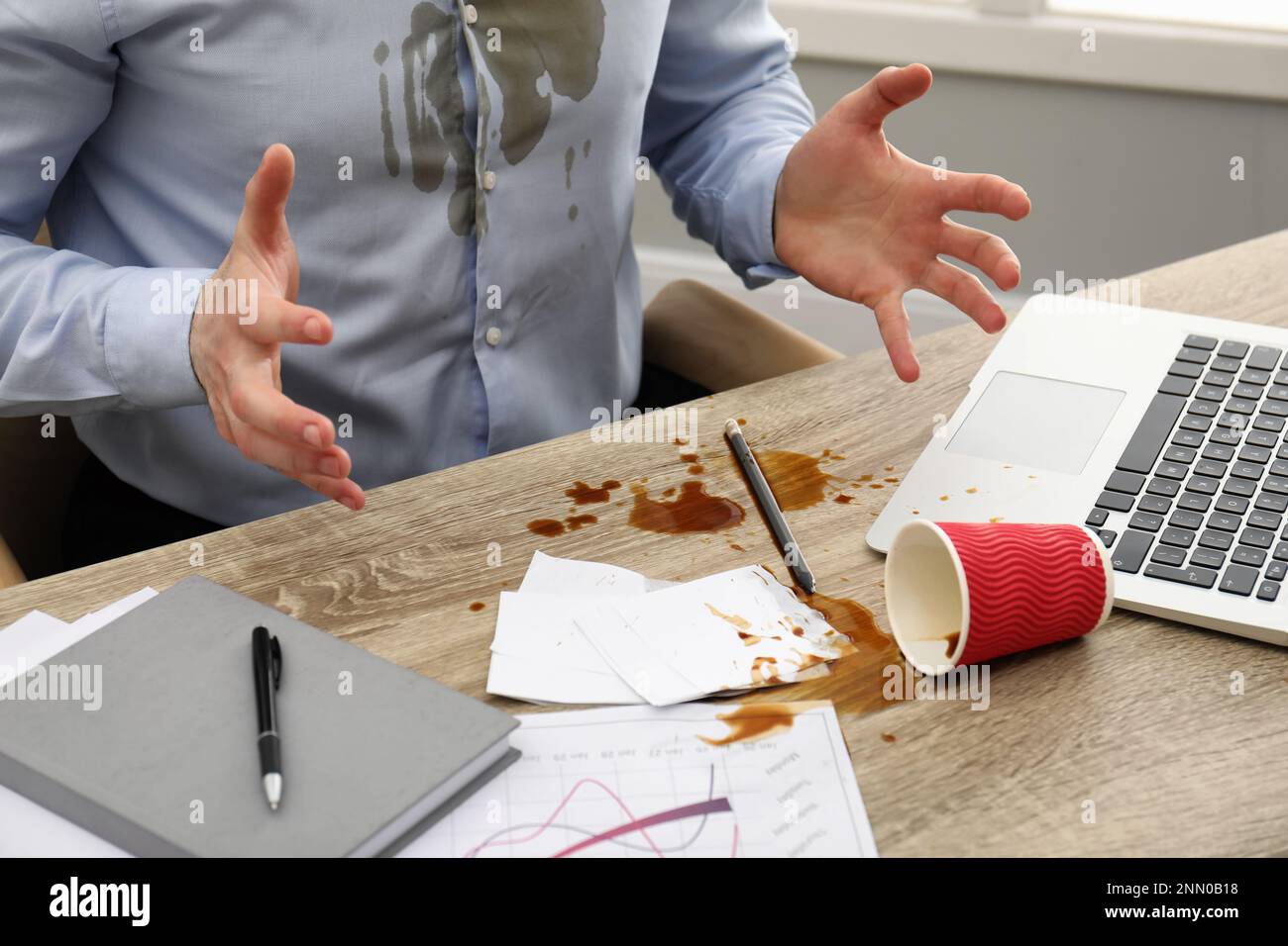 Homme avec du café renversé sur son lieu de travail et une chemise, gros plan Banque D'Images Homme avec du café renversé sur son lieu de travail et une chemise, gros plan Banque D'Images