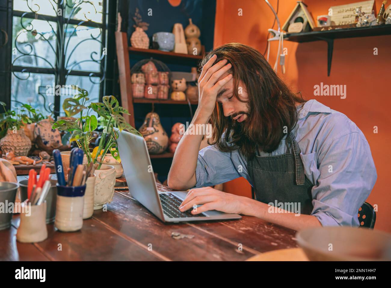 artiste travaillant dans un studio à domicile aucun contact avec le client ne fait pas faillite. homme mal de tête fatigué épuisé. Banque D'Images