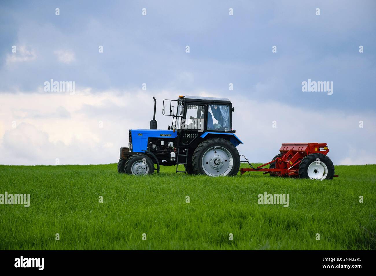 QUARTIER TELENESTI, MOLDOVA - MAI 2019: Tracteur à roues conducteur fertilisant le blé d'hiver avec des engrais minéraux. Alimentation des céréales. Rural la Banque D'Images