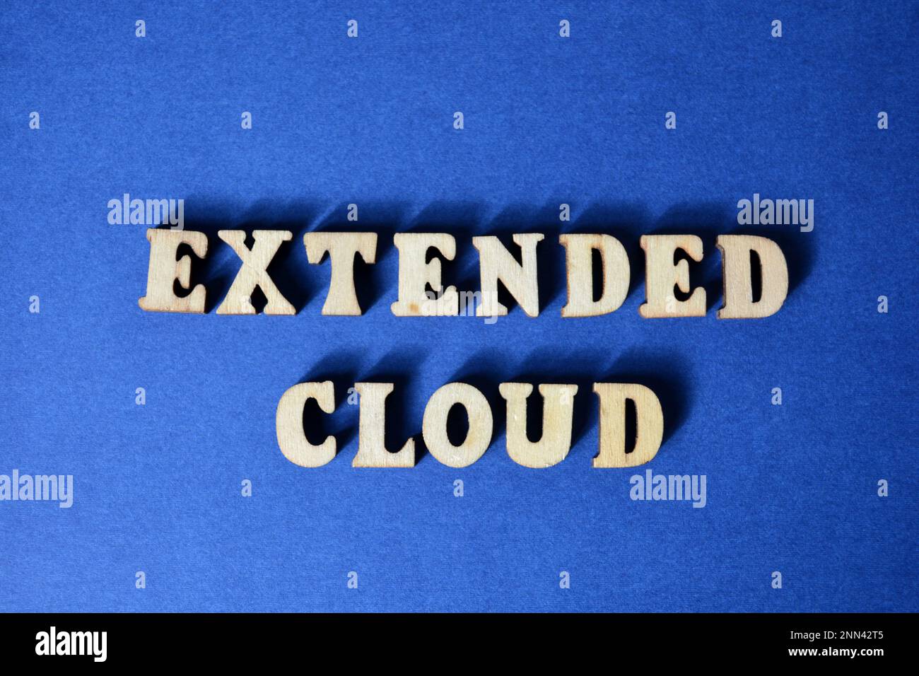 Extended Cloud, mot en lettres de l'alphabet en bois isolées sur fond bleu Banque D'Images