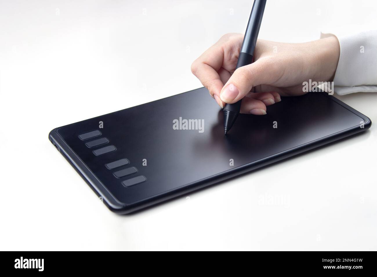 Femme écrivant à la main sur une tablette graphique sans fil sur un fond blanc Banque D'Images