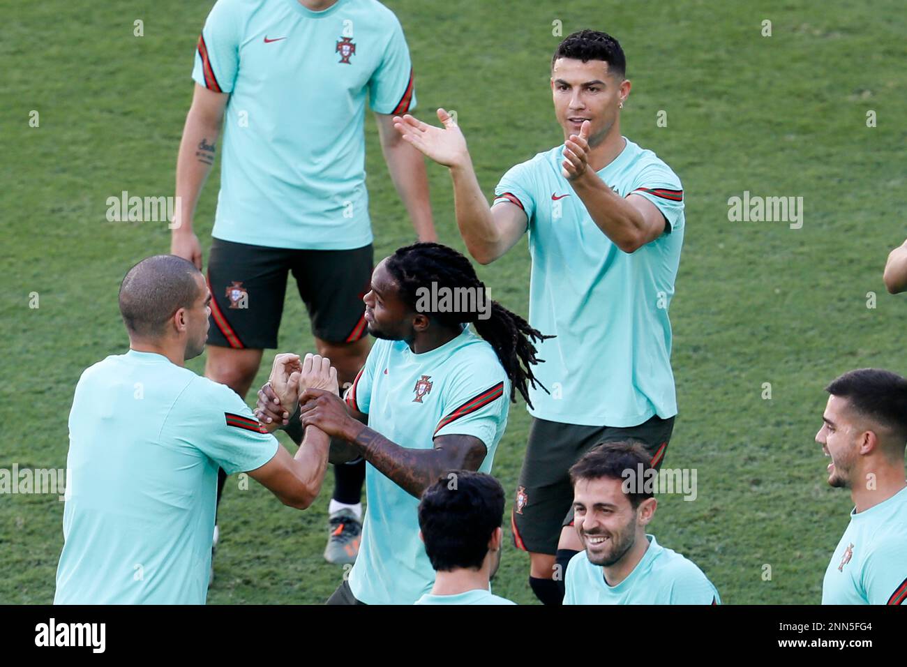 Portugal's Cristiano Ronaldo, right, applauds as Renato Sanches, center, holds the hands of Pepe during a training session at the La Cartuja stadium in Seville, Spain, Saturday, June 26, 2021. Portugal will play against Belgium on Sunday for the round of 16 of the Euro 2020 soccer championship.(Julio Munoz/Pool via AP) Banque D'Images