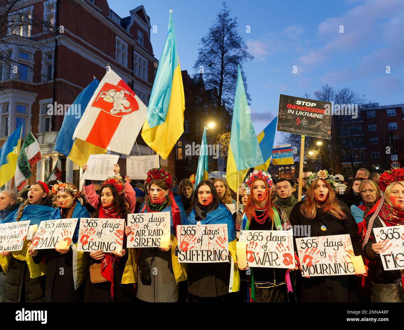 Vue de manifestants avec des banderoles lors d'une veillée allumée aux chandelles au consulat russe à Londres à l'occasion du premier anniversaire de l'invasion russe de l'Ukraine Banque D'Images