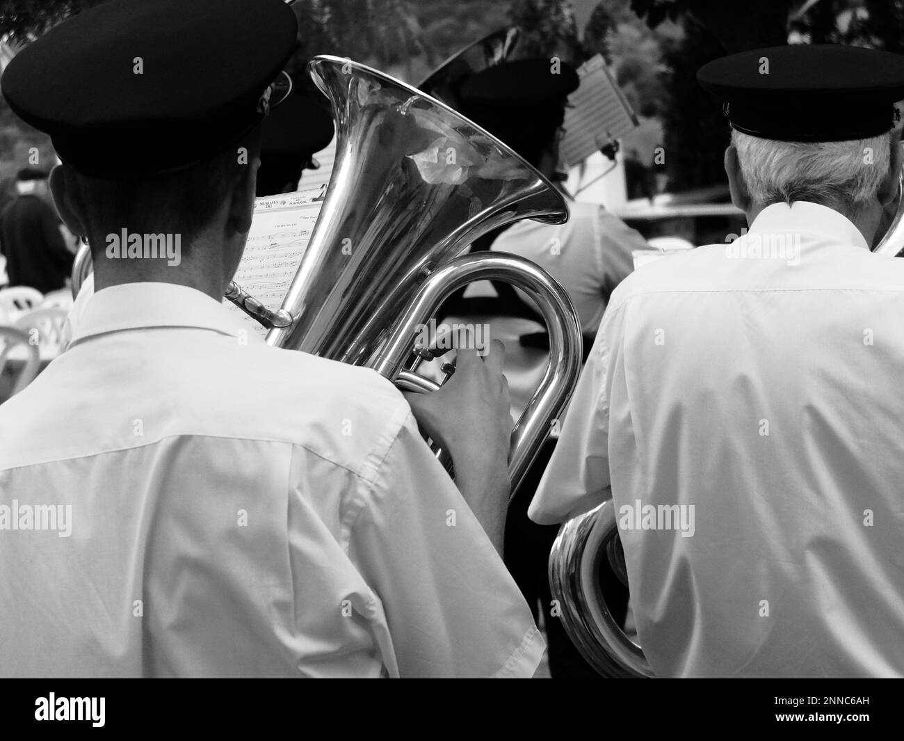 Un orchestre militaire jouant des tubas pendant un concert en plein air, vue arrière en noir et blanc Banque D'Images