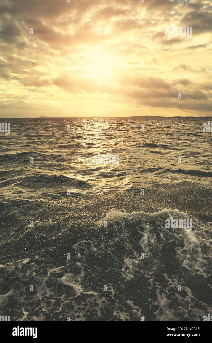 Mer agitée au coucher du soleil, couleurs vives appliquées. Banque D'Images