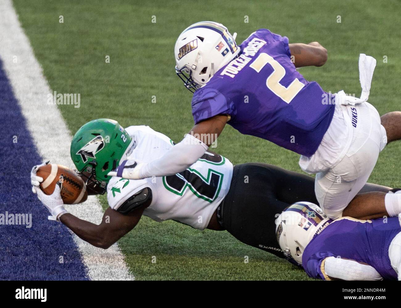North Dakota running back Otis Weah (26) dives in under James Madison linebacker Diamonte Tucker-Dorsey (2) for a touchdown during the first half of a quarterfinal game in the NCAA FCS football playoffs in Harrisonburg, Va., Sunday, May 2, 2021. (Daniel Lin/Daily News-Record via AP) Banque D'Images