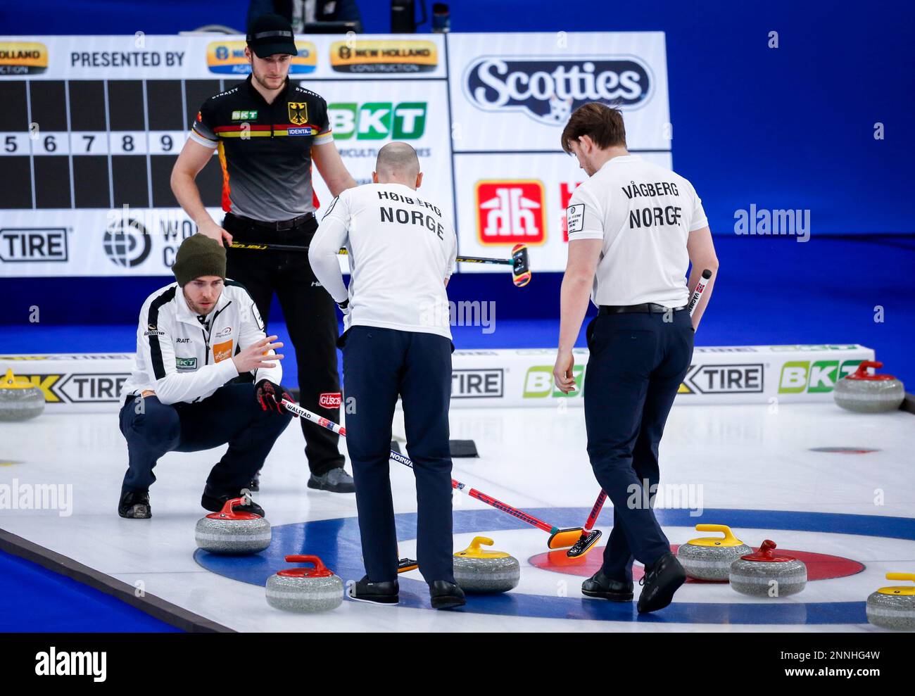 Norway skip Steffen Walstad, left, gestures to lead Magnus Vaagberg, right, and second Markus Hoeiberg, center, as Germany skip Sixten Totzek looks on at the men's World Curling Championships in Calgary, Alberta, Monday, April 5, 2021. (Jeff McIntosh/The Canadian Press via AP) Banque D'Images