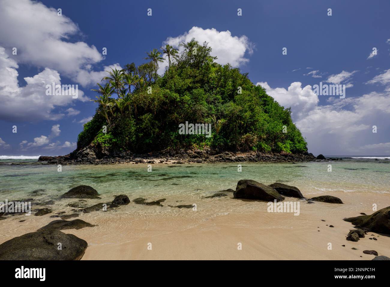 Les eaux claires le long de la côte d'Amanave sur l'île de Tutuila, Samoa américaines, avec sa plage de sable blanc et son feuillage luxuriant Banque D'Images