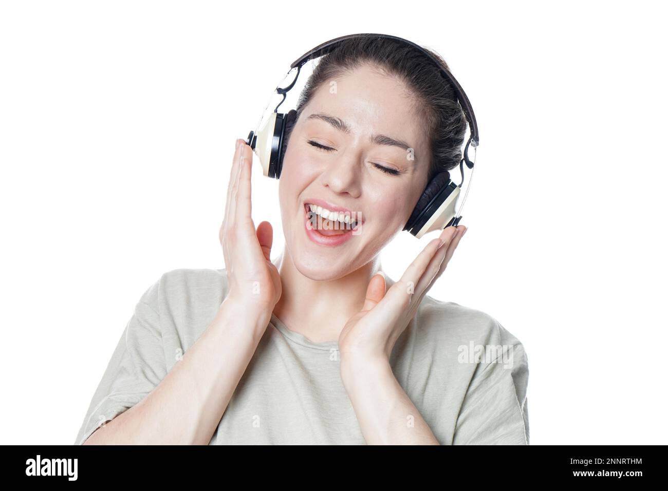 Happy young woman with headphones chanter sur de la musique avec les yeux fermés - isolé sur fond blanc Banque D'Images