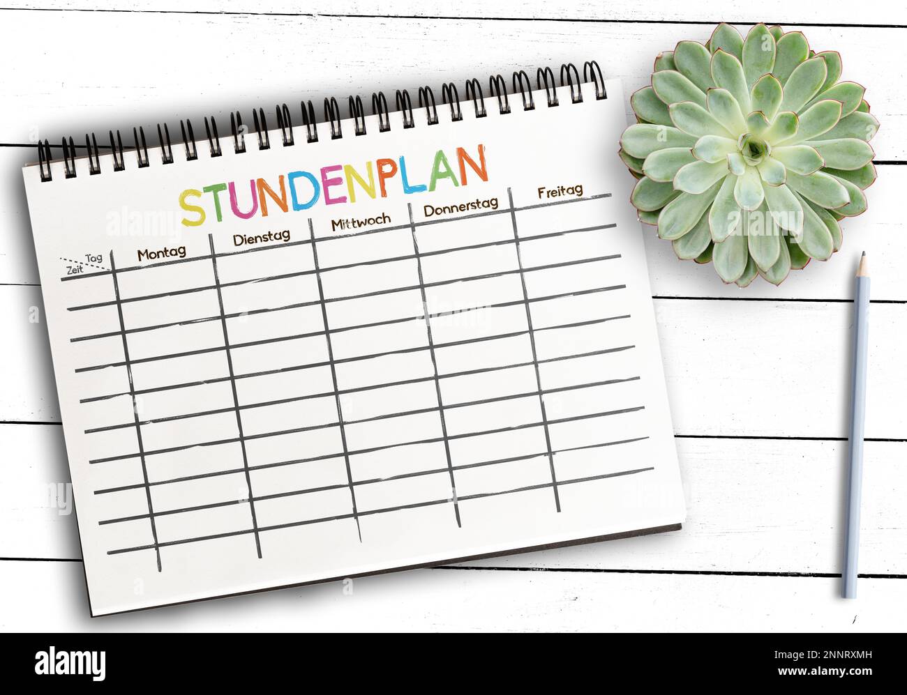 Vue de dessus de l'horaire des cours ou modèle d'horaire avec Word STUNDENPLAN, allemand pour l'horaire, sur le bloc-notes contre table rustique en bois blanc Banque D'Images