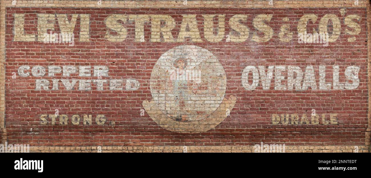Pub vintage Levi Strauss & Co peint sur un mur de briques Banque D'Images