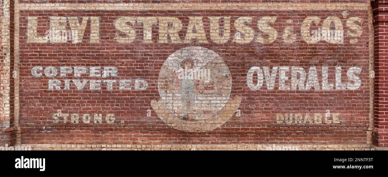 Pub vintage Levi Strauss & Co peint sur un mur de briques Banque D'Images