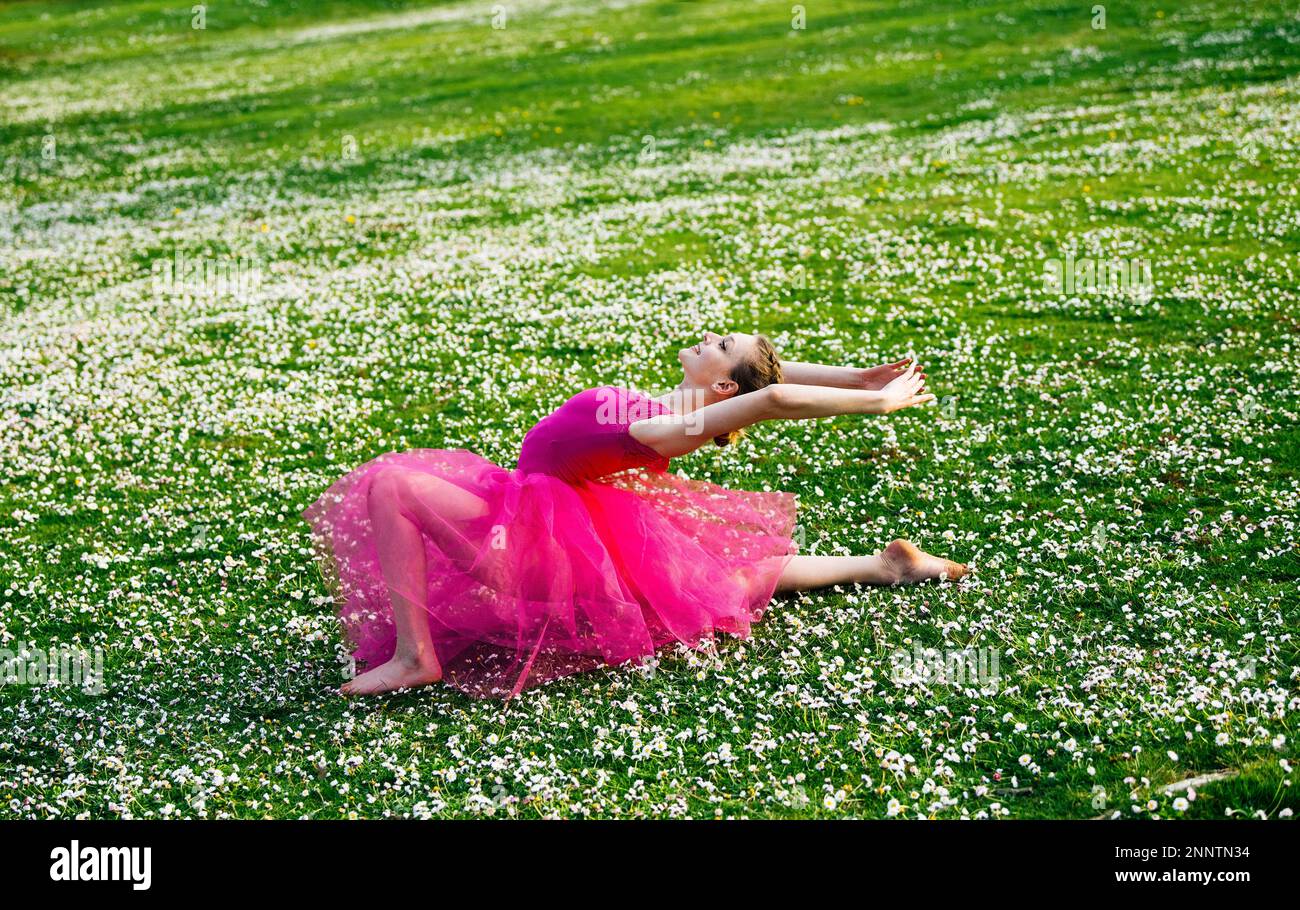 Ballerina faisant des fractionnements sur pelouse avec fleurs, parc de Battle point, île de Bainbridge, Washington, États-Unis Banque D'Images