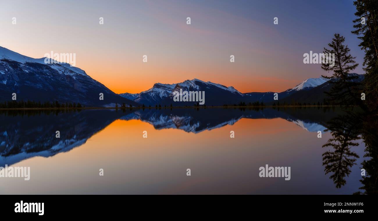 Chaîne de montagnes avec Pigeon Mountain reflétée dans Rundle forebay au coucher du soleil, Canmore, Alberta, Canada Banque D'Images