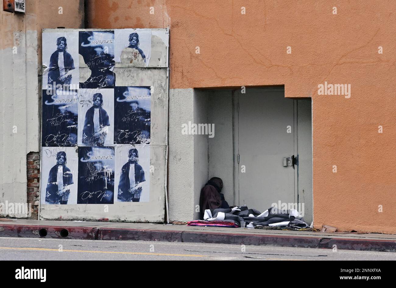 Un homme sans abri trouve un abri dans une alcôve lors d'une pause sous la pluie sur Sunset Blvd. Dans le centre-ville de Los Angeles, Californie le samedi, 25 février. 2023. Certaines parties de la Californie sont restées sous de graves avertissements météorologiques d'hiver pour une deuxième journée samedi, car les fonctionnaires de l'État ont continué à décourager les déplacements pendant la durée du week-end. Les avertissements de Blizzard sont également en vigueur jusqu'au dimanche dans le centre et le sud de la Sierra Nevada et les chaînes de montagnes transversales et péninsulaires. La dernière fois que le bureau de Los Angeles du service a émis un avertissement de blizzard était 1989. Photo de Jim Ruymen/UPI Banque D'Images