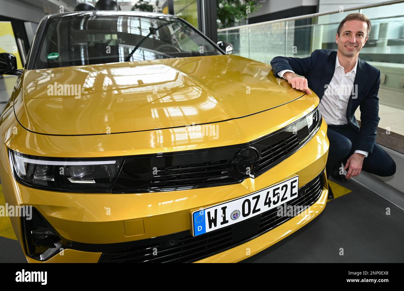 PRODUCTION - 24 février 2023, Hesse, Rüsselsheim: Florian Huettl, Directeur général d'Opel automobile GmbH, s'accroube à côté d'une Opel Astra au siège de la société. Opel fait partie du groupe de voitures Stellantis, formé par la fusion du constructeur Peugeot PSA et Fiat Chrysler. (À dpa : « Opel boss attend des ventes plus fortes pour l'année en cours ») photo : Arne Dedert/dpa Banque D'Images