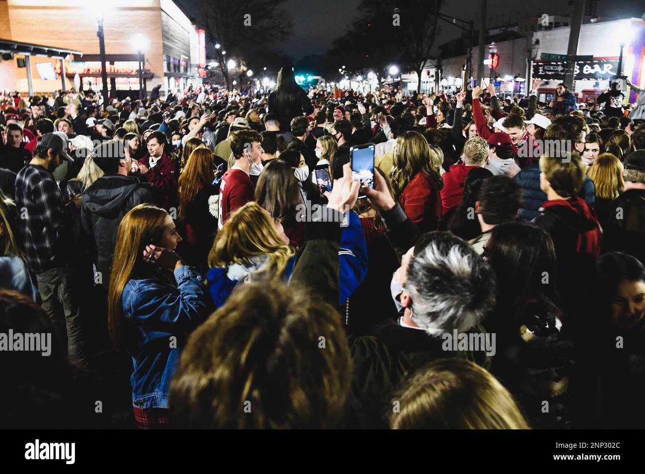 Alabama fans celebrate in the street in Tuscaloosa, Ala., Monday night, Jan. 11, 2021, after Alabama defeated Ohio State 52-24 in the NCAA college football national championship game in Miami Gardens, Fla. Many of the fans didn't take basic precautions against the coronavirus like wearing face masks. (Benjamin Flanagan/Alabama Media Group via AP) Banque D'Images