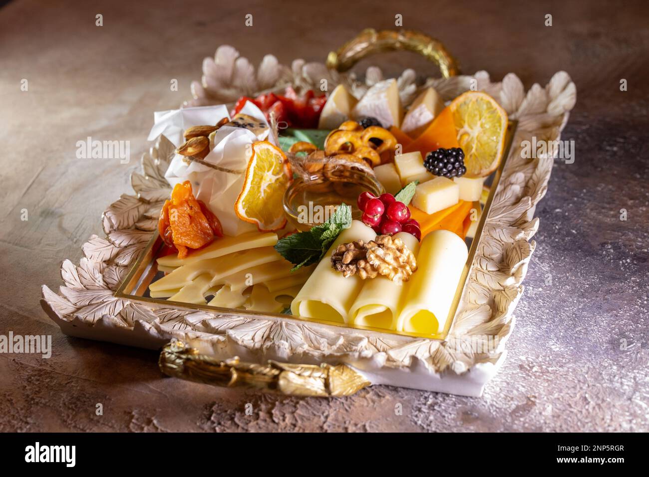 Assortiment de fromages sur un plateau avec noix et miel. Banque D'Images