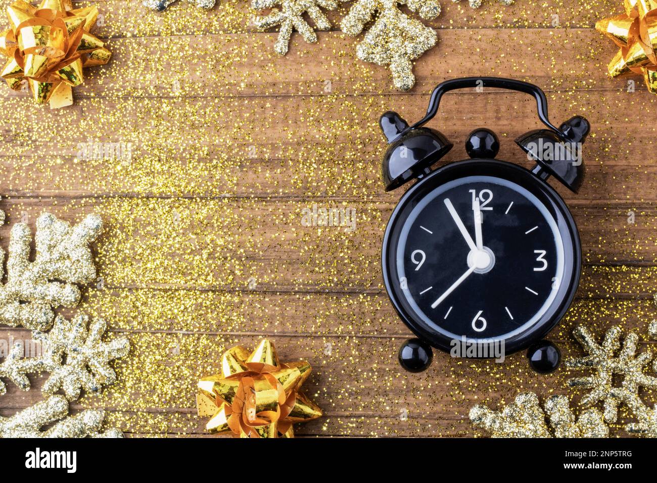 Horloge de style rétro comptant les derniers moments avant la messe de Noël ou le nouvel an, sur fond de bois vintage avec des reflets dorés et des arcs. Concept Chris Banque D'Images