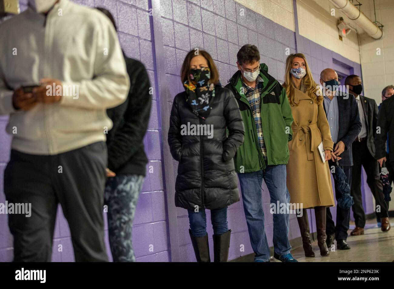 Georgia Republican Senator Kelly Loeffler, third from right, stands in line with her husband, Jeff Sprecher, second from right, to participate in early voting at Chastain Park Gymnasium in Atlanta, Wednesday, Dec. 16, 2020. Democrat senate candidates Jon Ossoff and Raphael Warnock are trying to unseat Republican Sens. Loeffler and David Perdue in Jan. 5 runoff elections that will determine which party controls the Senate. (Alyssa Pointer/Atlanta Journal-Constitution via AP) Banque D'Images