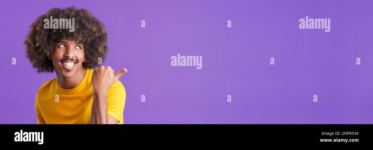 Un homme africain heureux qui pointe vers le côté Banque D'Images