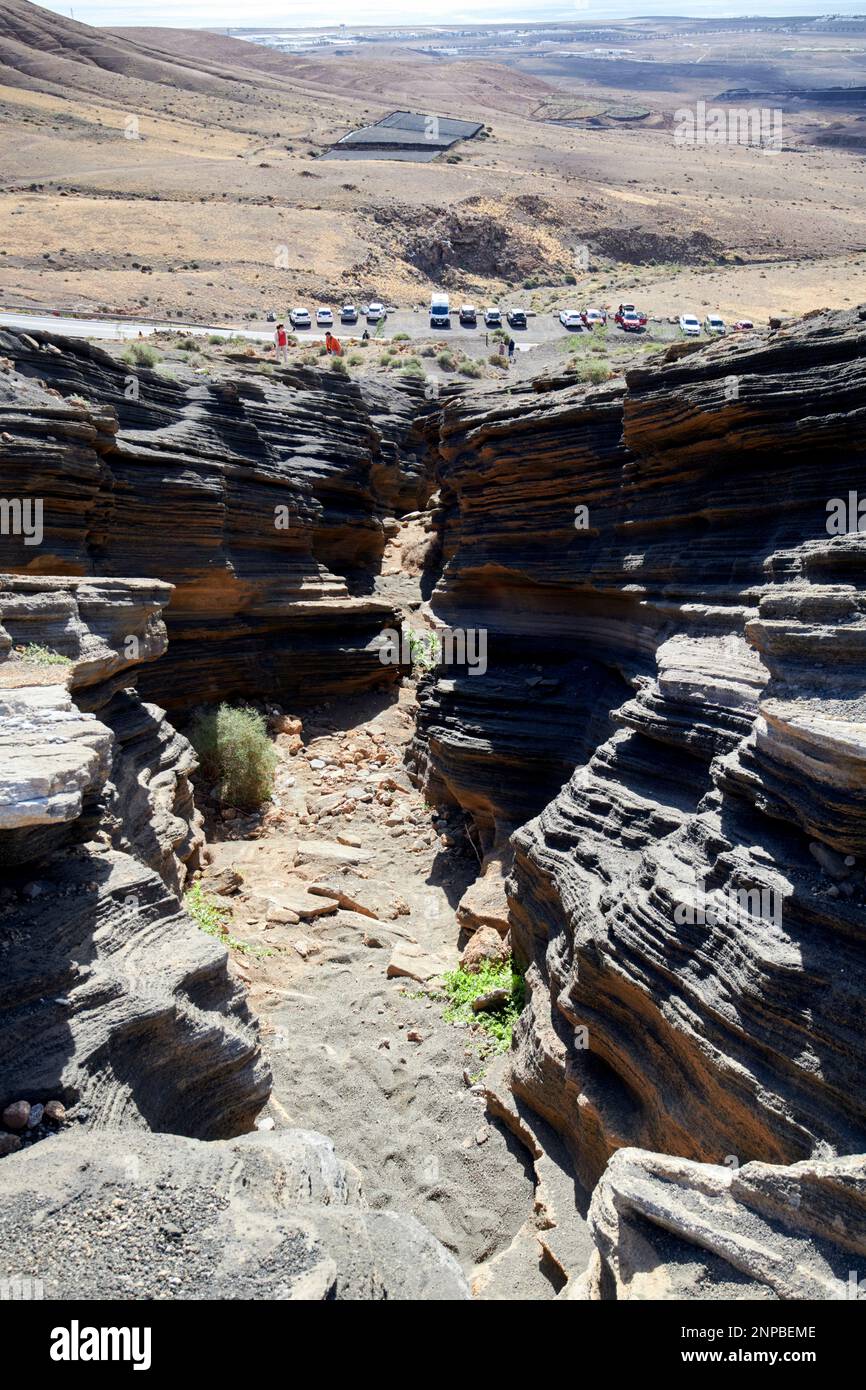 En regardant vers le parking de couches de Ladera Del volcan Las Grietas Lanzarote, îles Canaries, Espagne formations rocheuses volcaniques causées par l'érosion Banque D'Images