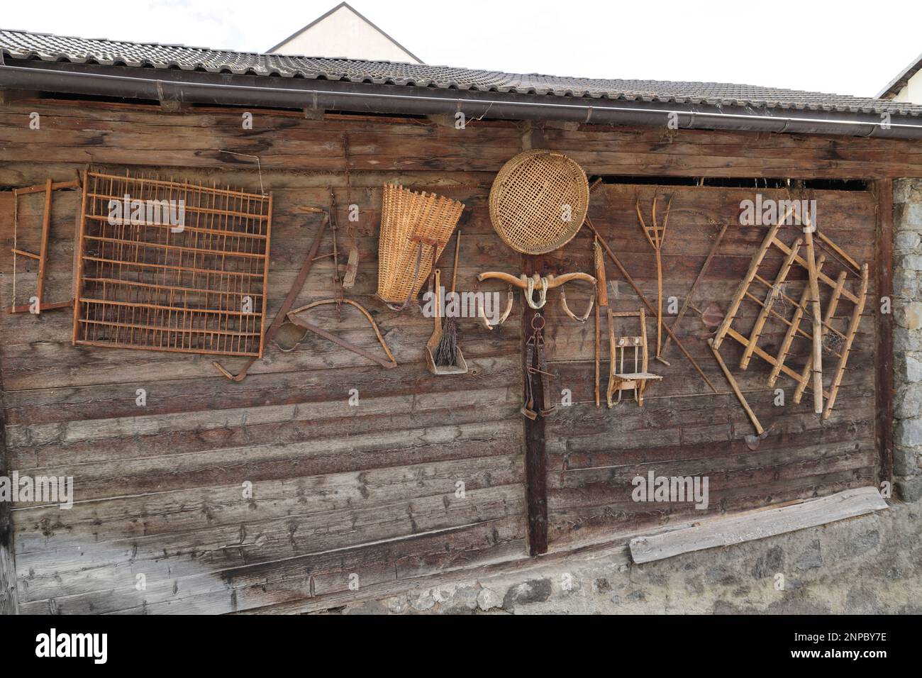 un vieux mur en bois avec un ancien outil agricole Banque D'Images