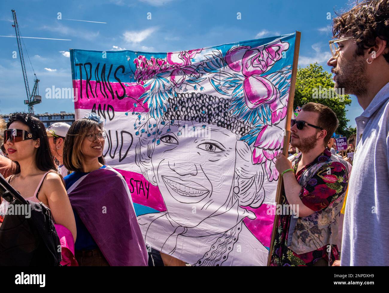 Un groupe de membres de la communauté LGBTQ+ proteste contre le manque de droits et de soins de santé pour les personnes transgenres tenant une bannière avec les mots Trans et fier à Hyde Park. Banque D'Images