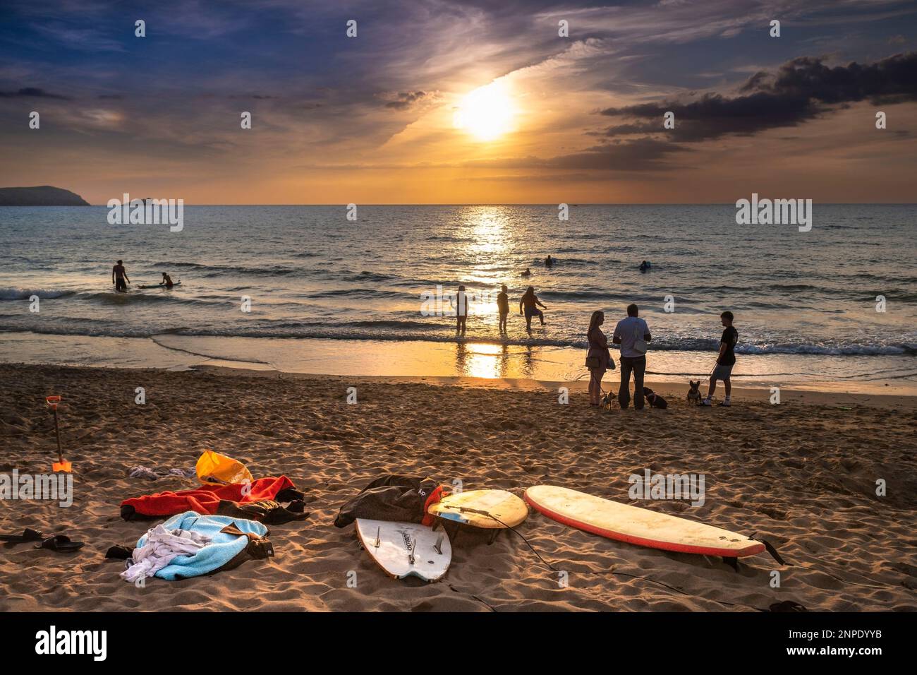 Vacanciers profitant d'un coucher de soleil spectaculaire sur la baie de Fistral à Newquay en Cornouailles au Royaume-Uni en Europe. Banque D'Images