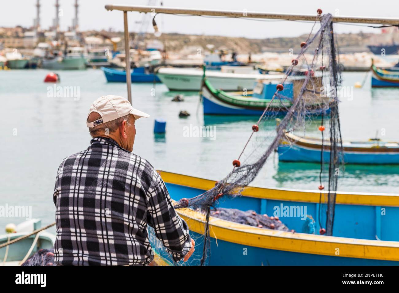 Un pêcheur a vu inspecter ses filets de pêche à Marsaxlokk à Malte. Banque D'Images