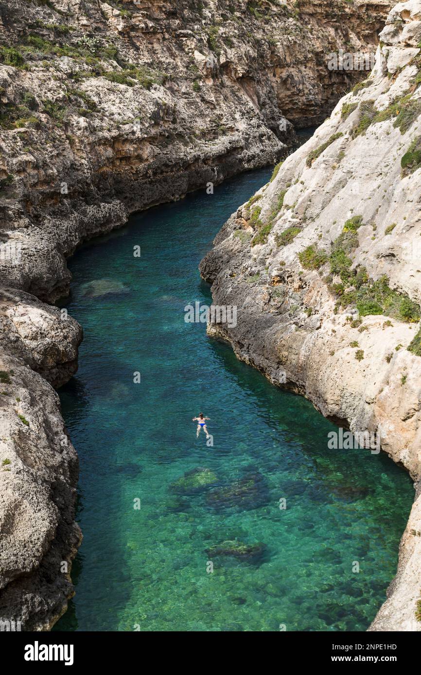 Une jeune femme nageant pour voir dans la gorge étroite de Wied il-Ghasri sur l'île de Gozo. Banque D'Images