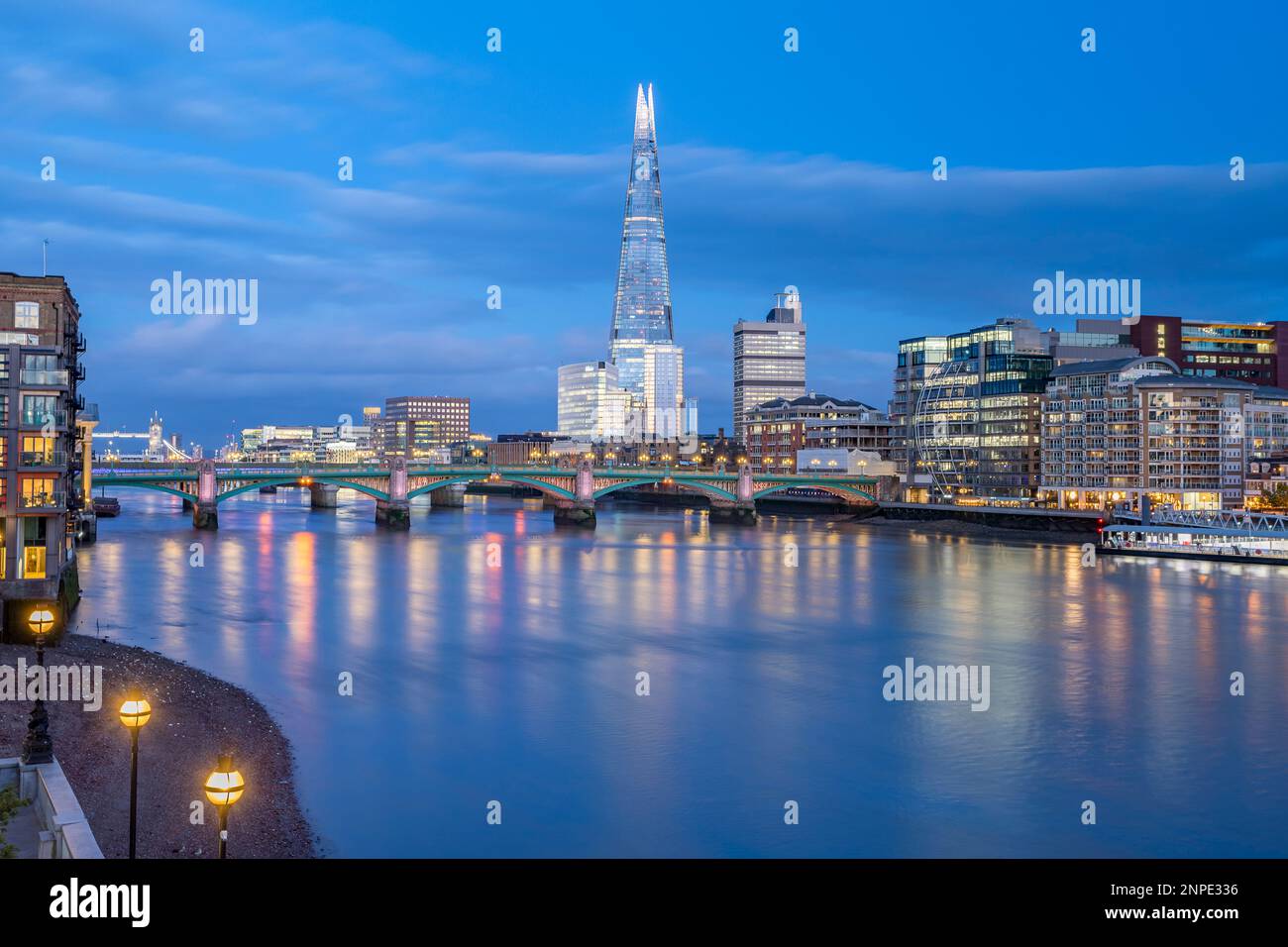 Le pont Southwark et le Shard vus de la rive de la Tamise au crépuscule. Banque D'Images