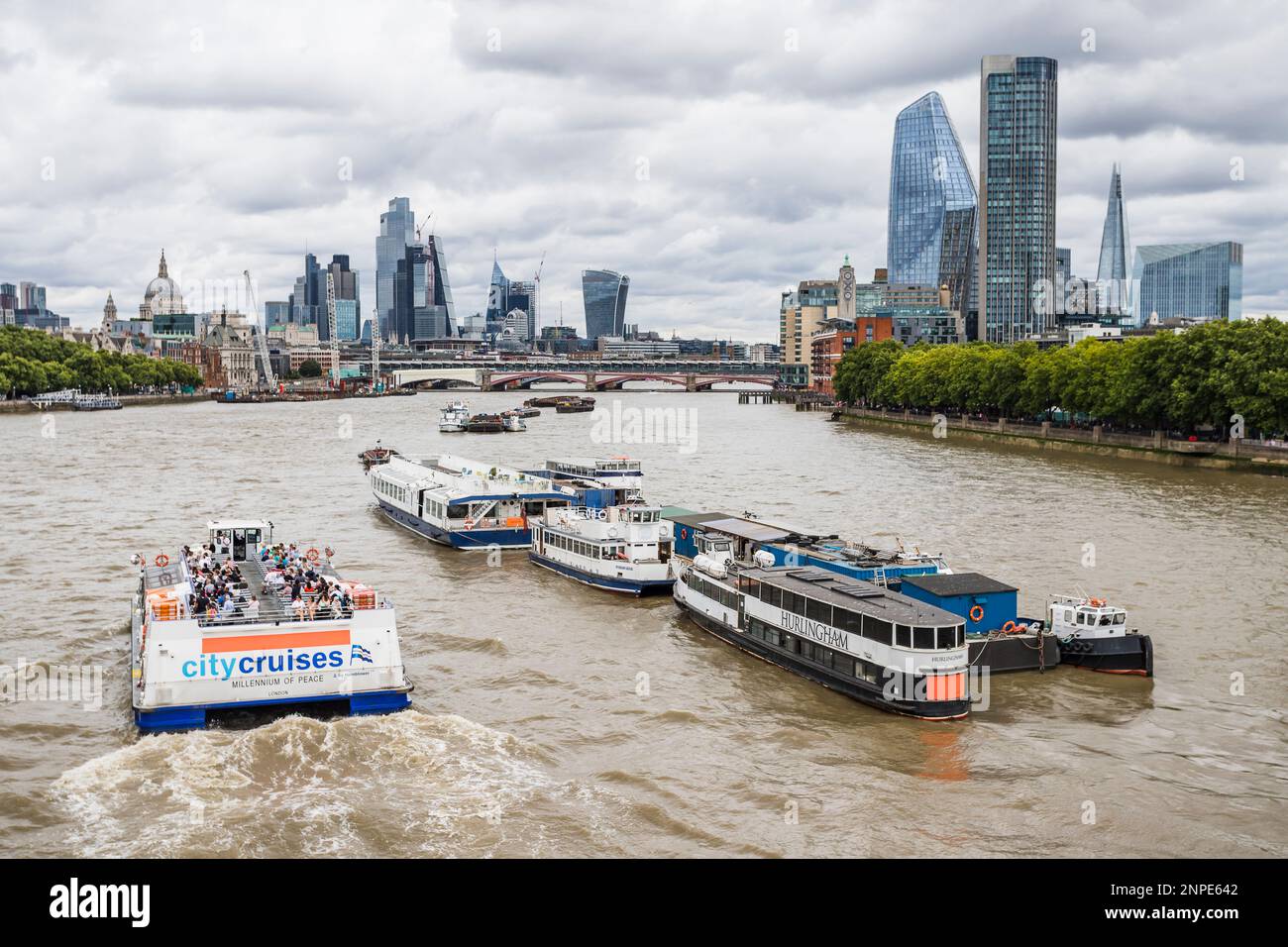Une embarcation de passagers sur la Tamise à Londres se rend vers l'est en direction de Tower Bridge et du Square Mile. Banque D'Images
