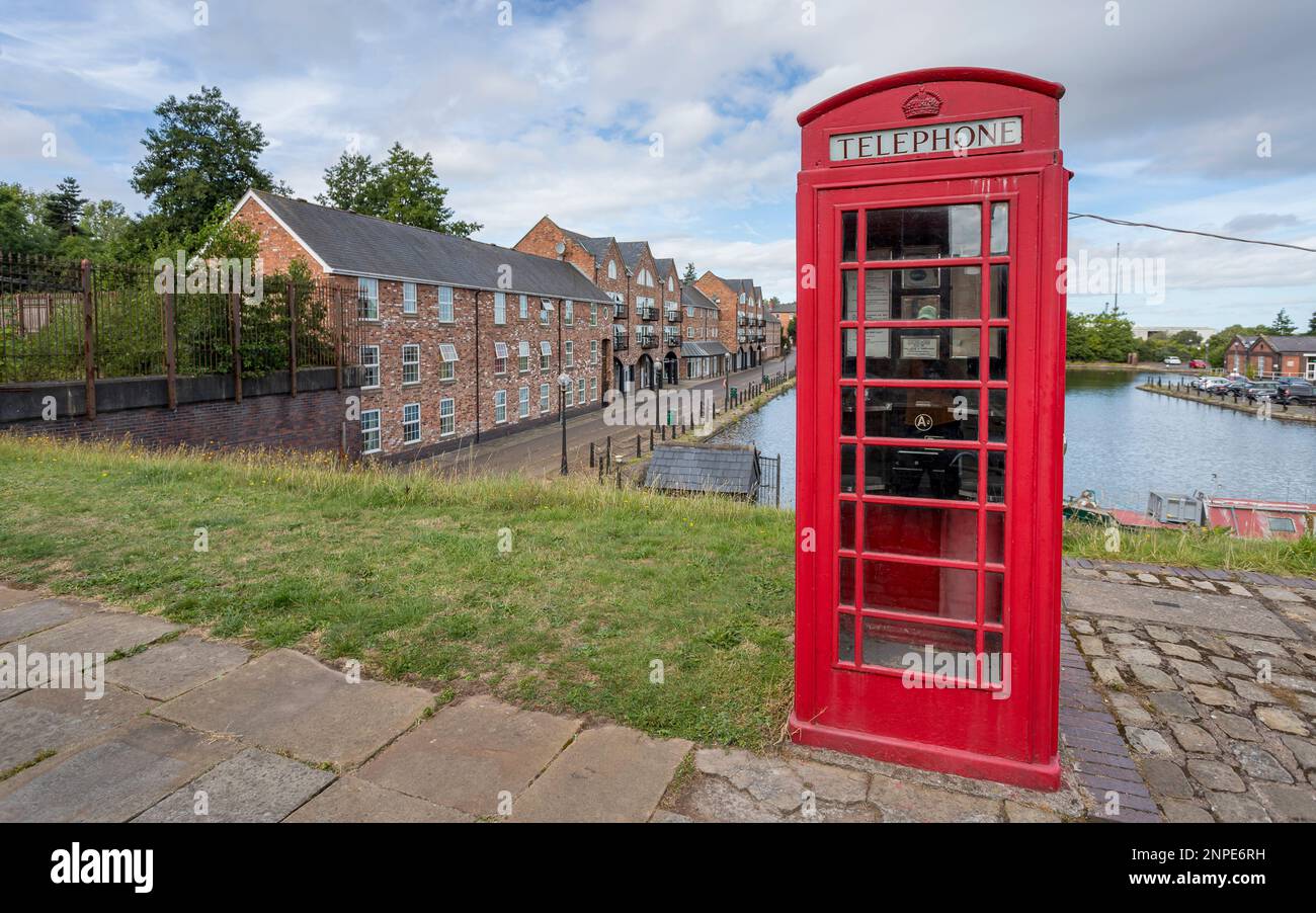 Ancienne boîte téléphonique rouge vue devant le bassin du canal du port d'Ellesmere à Cheshire. Banque D'Images