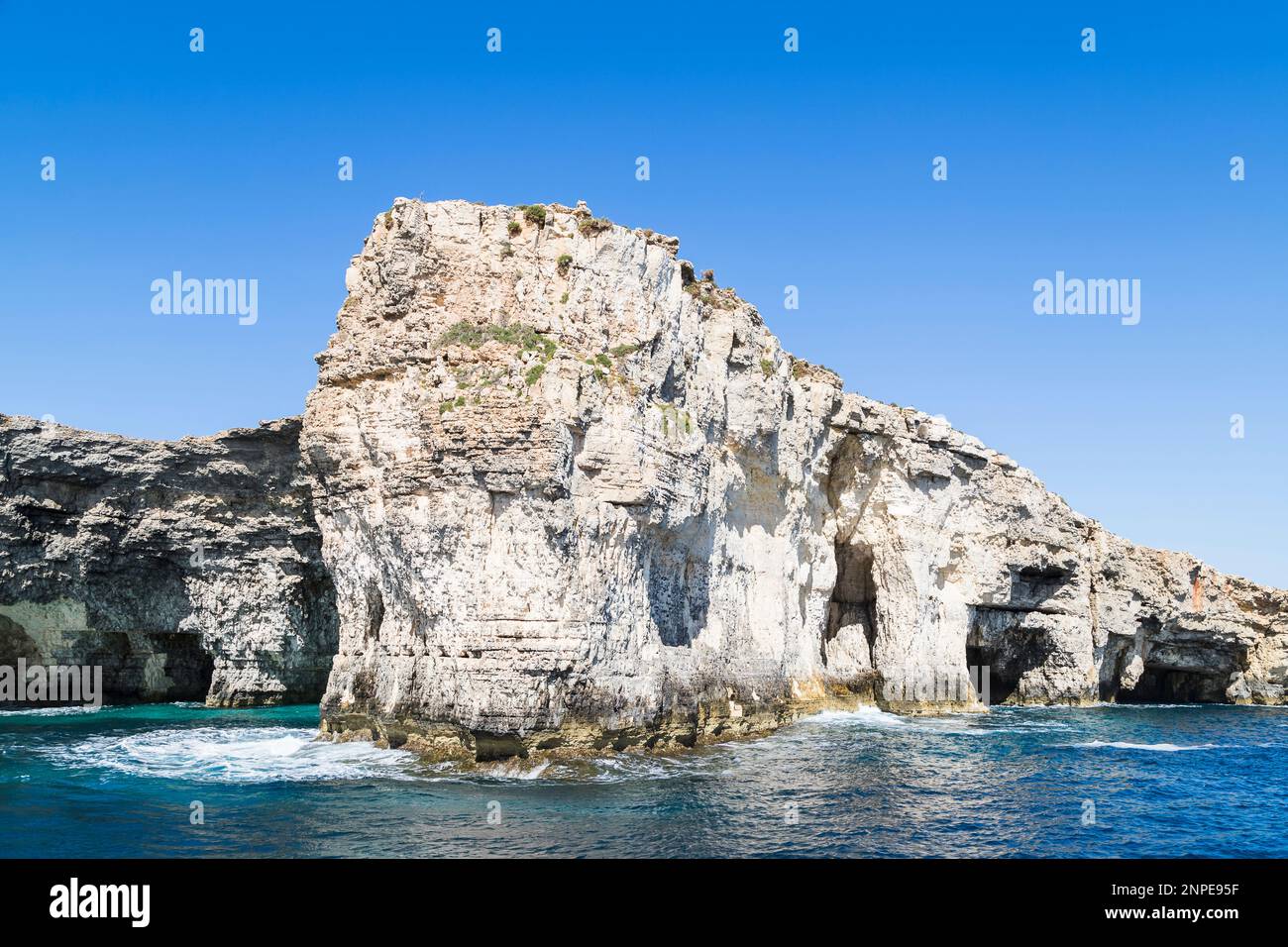Les vagues se sont écrasées contre des falaises et des grottes marines sur l'île de Comino à Malte. Banque D'Images