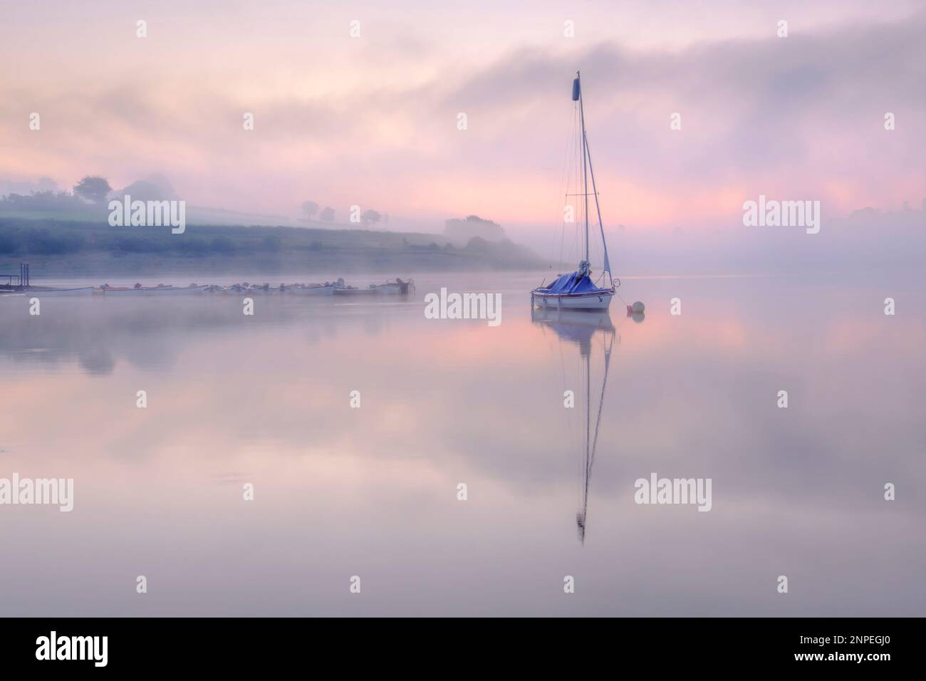 Un bateau dans la brume sur le lac Wimbleball à Exmoor. Banque D'Images
