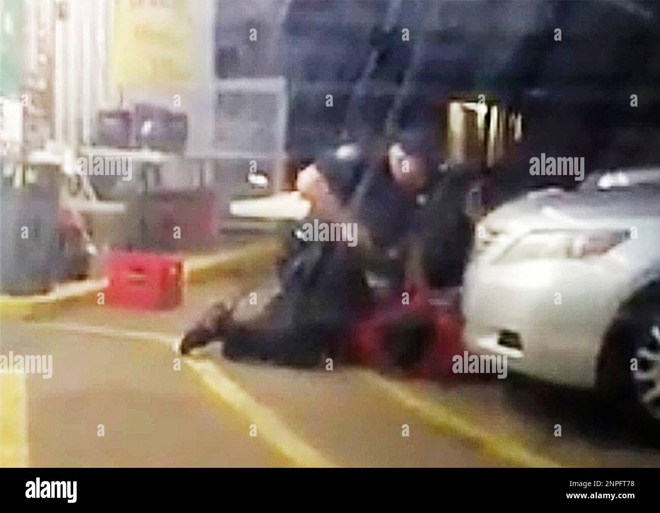 FILE - In this July 5, 2016, image made from video provided by Arthur Reed, Alton Sterling, in red, is restrained by two Baton Rouge police officers, one holding a gun, outside a convenience store in Baton Rouge, La. Moments later, one of the officers shot and killed Sterling, a black man who had been selling CDs outside the store, while he was on the ground. Howie Lake II, a white Louisiana police officer who assisted in the arrest in which Sterling was fatally shot, was dismissed Monday, Sept. 21, 2020, from a wrongful death lawsuit. (Arthur Reed via AP, File) Banque D'Images