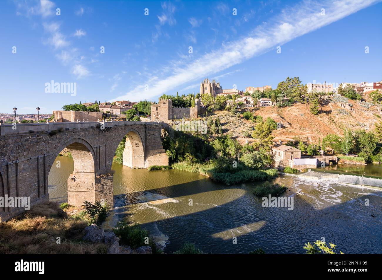 Vue sur le pont de San Martin traversant le Tage pour entrer dans la vieille ville de Tolède sur la colline où vous voyez la vieille cathédrale Banque D'Images