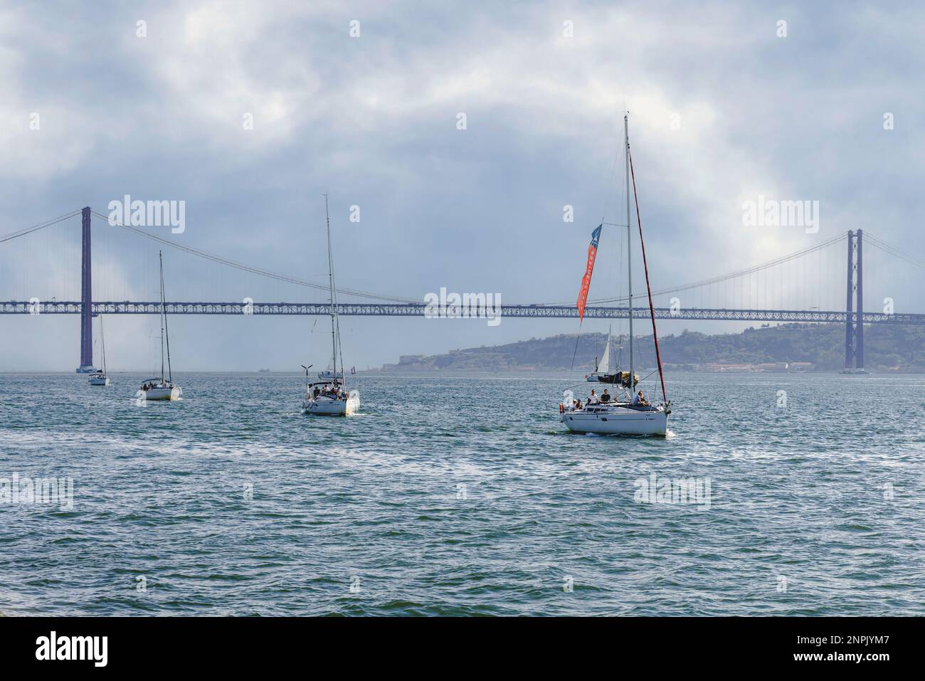 Lisbonne, Portugal. Yachts sur le Tage avec le pont de 2 277 mètres de long Ponte 25 de Abril/25th April Bridge en arrière-plan. Banque D'Images
