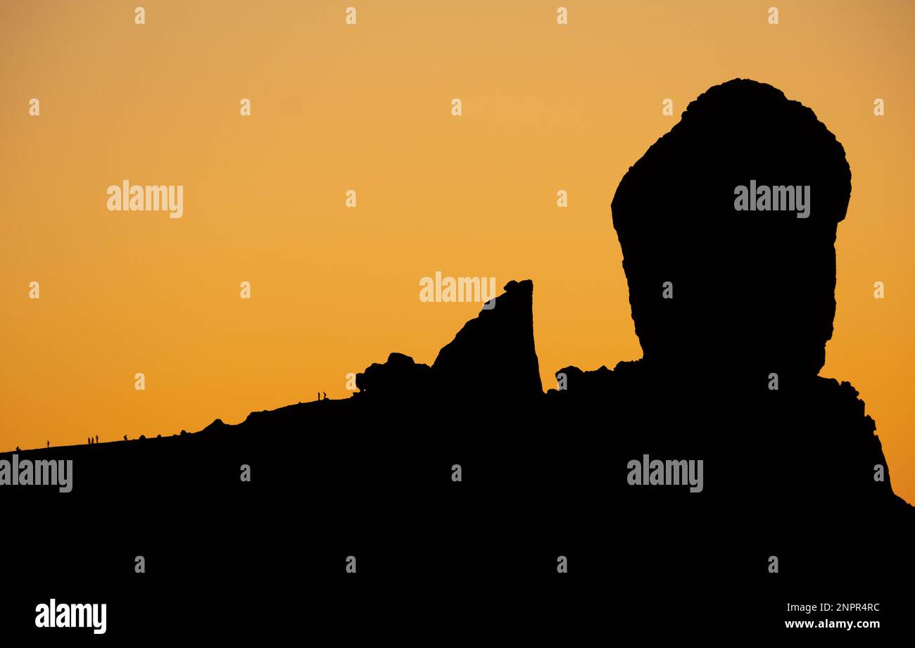 Gran Canaria, Îles Canaries, Espagne. 25th février 2023. Les gens ressemblent à des fourmis en regardant le coucher du soleil depuis la base de Roque Nublo (rocher nublo), en hauteur dans les montagnes de la Grande Canarie. Credit: AlanDawson/Alamy Live News Banque D'Images