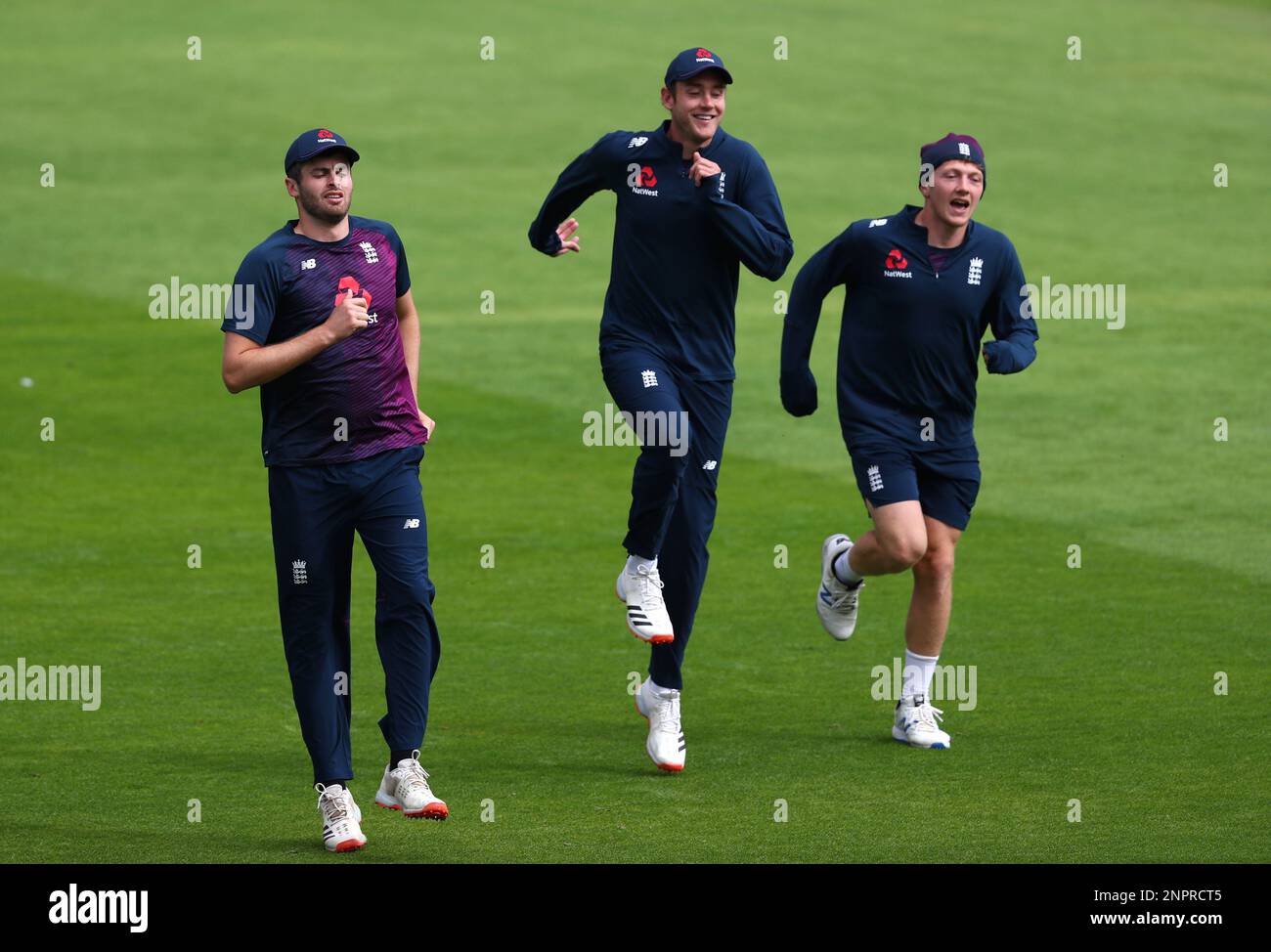 England's Dom Sibley, left, Stuart Broad, center, and Dominic Bess warm up ahead of the second day of the third cricket Test match between England and West Indies at Old Trafford in Manchester, England, Saturday, July 25, 2020. (Michael Steele/Pool via AP) Banque D'Images
