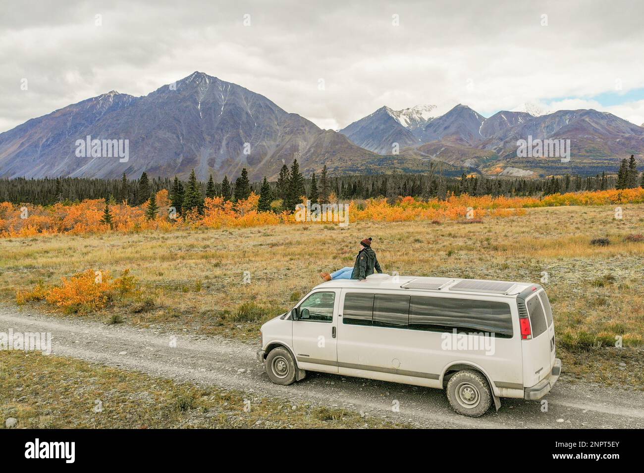 Voyager au-dessus d'une camionnette de camping pendant la saison d'automne avec un arrière-plan incroyable de montagnes. Banque D'Images